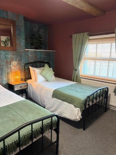 a bedroom with two beds and a window at The Black Swan Inn in Leominster