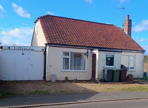 a small white house with a red roof at Littleholme in Potter Heigham