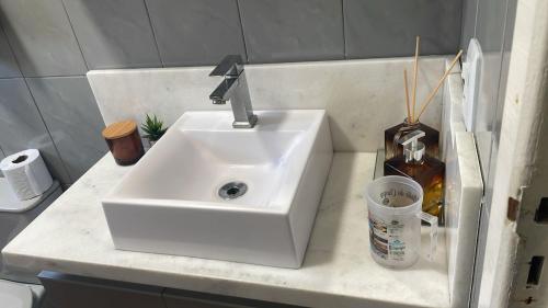 a white sink in a bathroom with a toilet at Pousada Erdmann in São Gabriel
