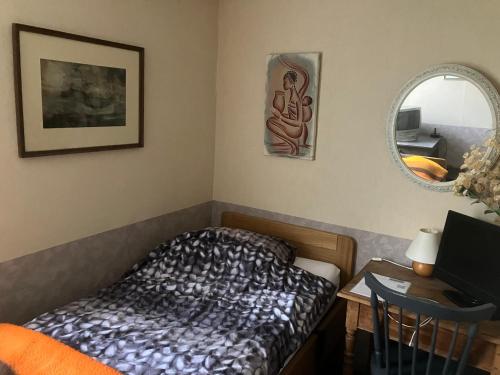 a bedroom with a bed and a desk with a mirror at Het werkhuis, terug in de tijd in Uden