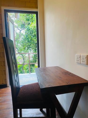 une table en bois avec une chaise et une fenêtre dans l'établissement Arazo villa, à Unawatuna