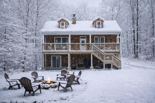 a log cabin in the snow with a fire at Catskill Cabin with Firepit & Indoor Jacuzzi Tub in Catskill