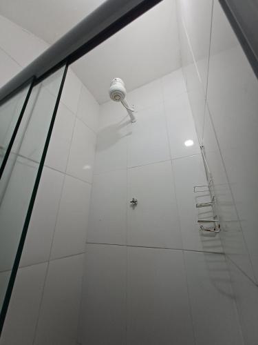 a shower with a light in a white wall at Studio Com Ar Condicionado na Manoel Novais in Serrinha