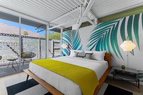 una camera da letto con un letto con una coperta gialla di Limon Palm Springs A Luxury Boutique Hotel a Palm Springs