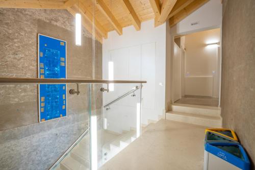 una scala in vetro in una stanza con parete blu di B&B Ca' Serena wine retreat a Ledro