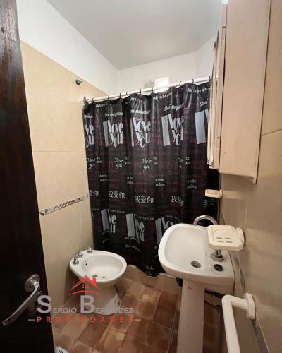 a bathroom with a sink and a shower curtain at Departamento del Tuyu in Mar del Tuyú