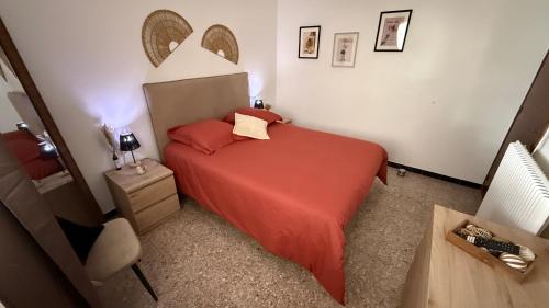 a small bedroom with a red bed and a table at Mare è Muntagna in Mignataja