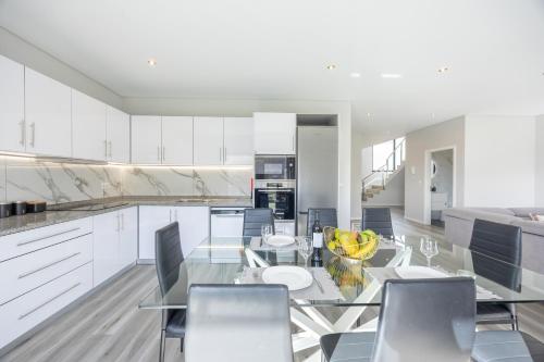 a dining room with a glass table and chairs at Paradise Pereira House BY YOUR KEY MADEIRA in Calheta