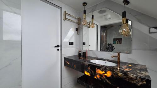 a bathroom with a sink and a mirror at Urocze Gniazdko pod Tatrami in Ratułów