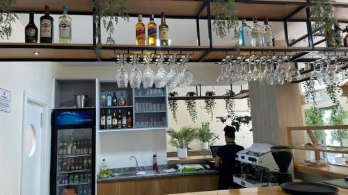 a man standing at a bar with wine glasses at Urban Hostel Mindelo in Mindelo