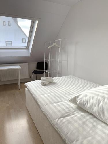 una camera da letto bianca con un letto grande e una finestra di Helles & Modernes Apartment in Heilbronn a Heilbronn