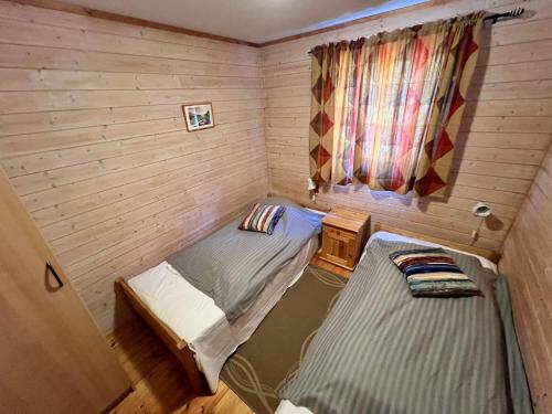 two twin beds in a corner of a room at Øen Hytter 1 in Sørbø