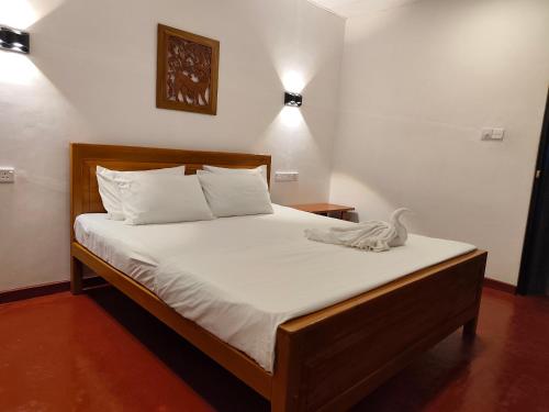 a bedroom with a bed with white sheets at Ayuvilla in Goiyapana