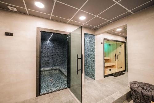 a bathroom with a shower with a glass door at Hotel Emeraude in Peisey-Nancroix