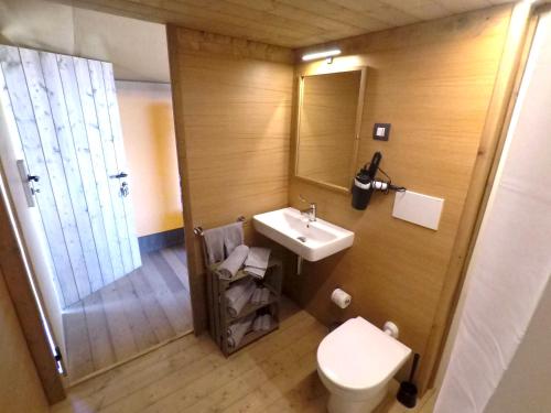 un bagno con lavandino, WC e specchio di Glamping Podere Poggiagrilli a San Gervasio