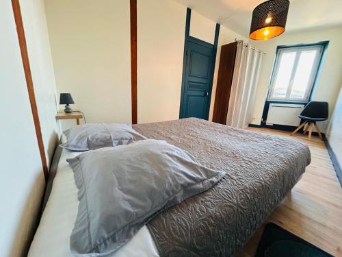 a bedroom with a bed and a blue door at Gîte de l'auberge in Lupé