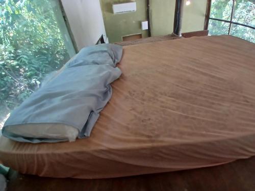a wooden bed with a blanket on top of it at Camburi Chalet - por do sol in São Sebastião