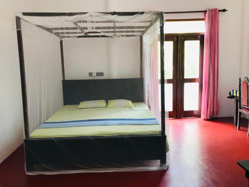 a bed with a canopy in a room at Sun Shine House in Matara