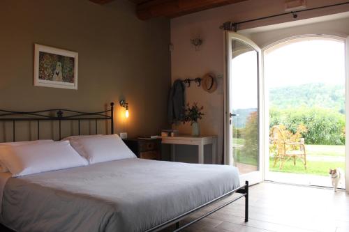 een slaapkamer met een bed en een glazen schuifdeur bij Agriturismo Ceriano in Modigliana