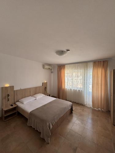 a bedroom with a large bed and a large window at Casa Silvia in Costinesti