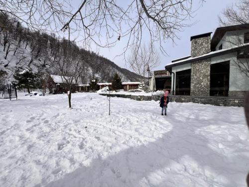 a person standing in the snow in front of a building at Istisu Valley Spa in İsmayıllı