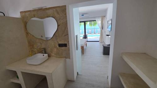 a bathroom with a sink and a mirror on the wall at Bless Villa Apartment in Kiwengwa