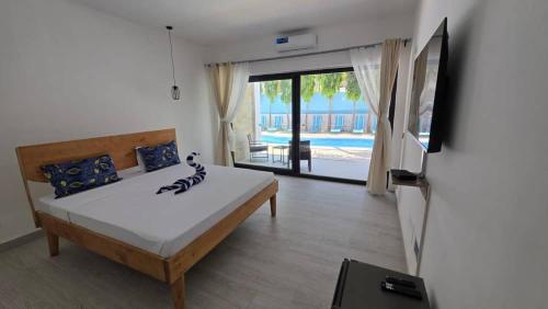 a bedroom with a bed and a view of a pool at Bless Villa Apartment in Kiwengwa