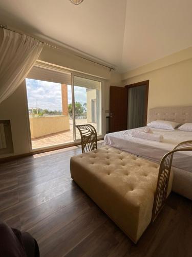 a bedroom with two beds and a large window at Villa Prestige avec piscine in Tamaris