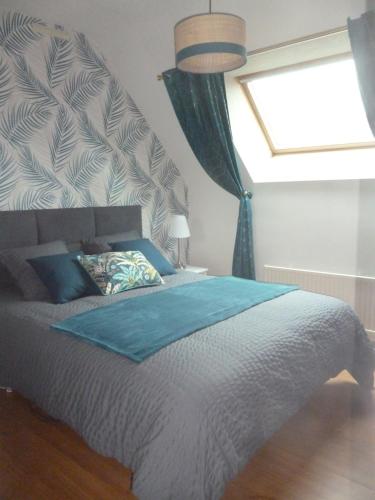 een slaapkamer met een groot bed en een raam bij Au gré des marées, 2 chambres in Hanvec