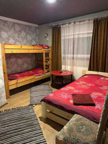een slaapkamer met twee stapelbedden en een tafel bij Tolli Hostel & Holiday House in Valga