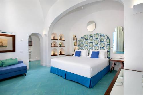 a bedroom with a bed and a blue couch at Grand Hotel Europa Palace Sorrento in Sorrento