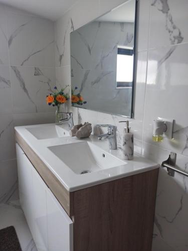 a white bathroom with a sink and a mirror at Casa da Figueira in Guilhufe