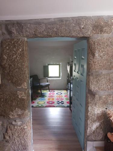 a doorway into a room with a stone wall at Casa da Figueira in Guilhufe