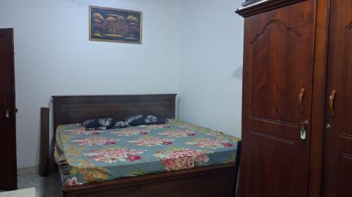 a bedroom with a bed and a wooden cabinet at WIJAYA Rest in Gampaha