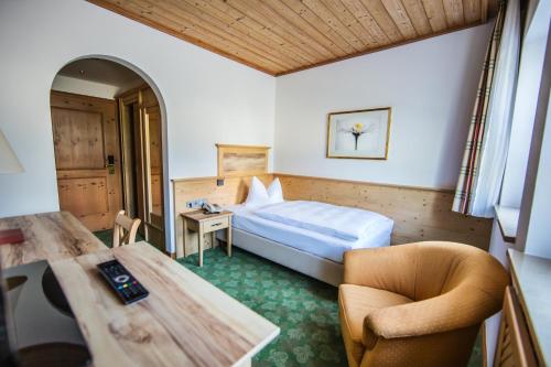 a hotel room with a bed and a table and chairs at Glasl's Landhotel in Zorneding