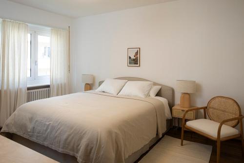 a bedroom with a bed and a chair and a window at Maraini Deluxe Apartment - free parking in Massagno