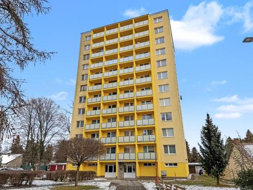 un condominio giallo con neve a terra di Apartment Hemsen a Spišská Nová Ves