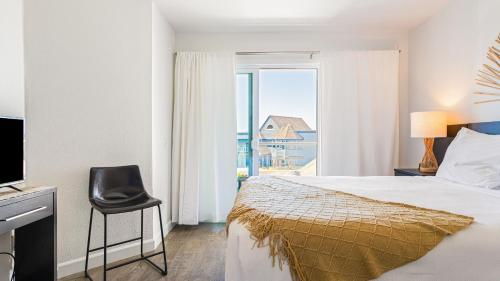 una camera da letto con un letto, una sedia e una finestra di 2 Cayucan Bungalows Steps to Beach Shared Lounge Sleeps 12 a Cayucos