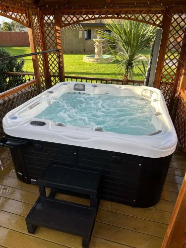 a jacuzzi tub on a deck with a porch at Detached property, beams, hot tub large garden in Broadwey