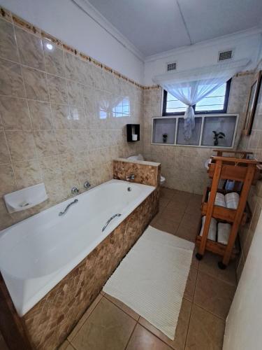 a large bathroom with a tub and a window at 83 Ocean View in Port Shepstone