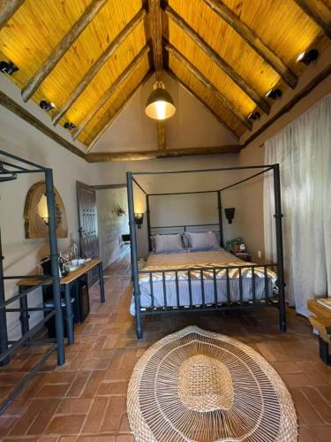 a bedroom with a bed with a wooden ceiling at Chalé Casa da Pedra in Cunha