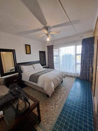 a bedroom with a bed and a ceiling fan at 83 Ocean View in Port Shepstone