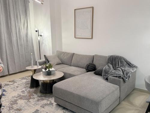a living room with a gray couch and a table at Luxury 1BR on Reem Island Private Parking in Abu Dhabi