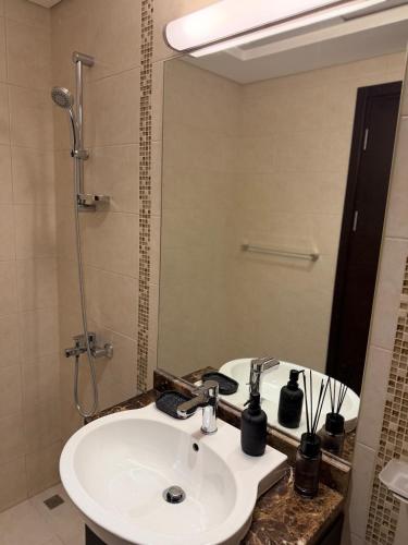 a bathroom with a sink and a mirror at Luxury 1BR on Reem Island Private Parking in Abu Dhabi