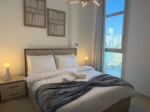 a bedroom with a large bed with a large window at Luxury 1BR on Reem Island Private Parking in Abu Dhabi