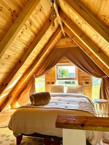 a cat laying on a bed in a attic at Cabañas RyL Aeropuerto in Puerto Montt