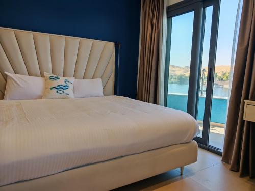 a bedroom with a large bed with a large window at Villa Swenet in Aswan