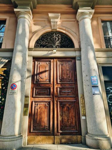 a large wooden door of a building with two columns at Monti26 in Milan