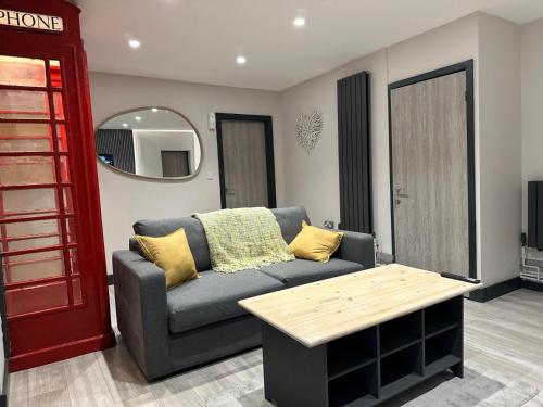 ein Wohnzimmer mit einem Sofa und einer roten Telefonzelle in der Unterkunft 6Adelphi in Preston