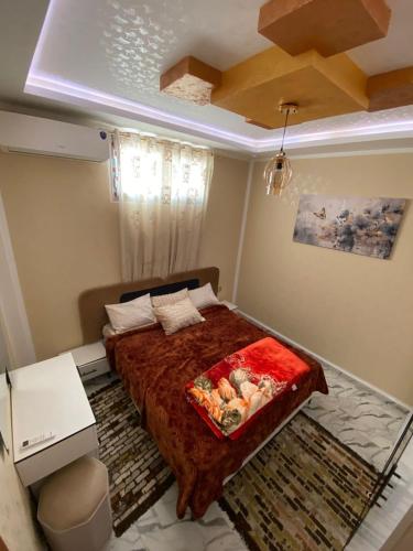a bedroom with a bed with a red blanket at Dar Hamma in Tozeur